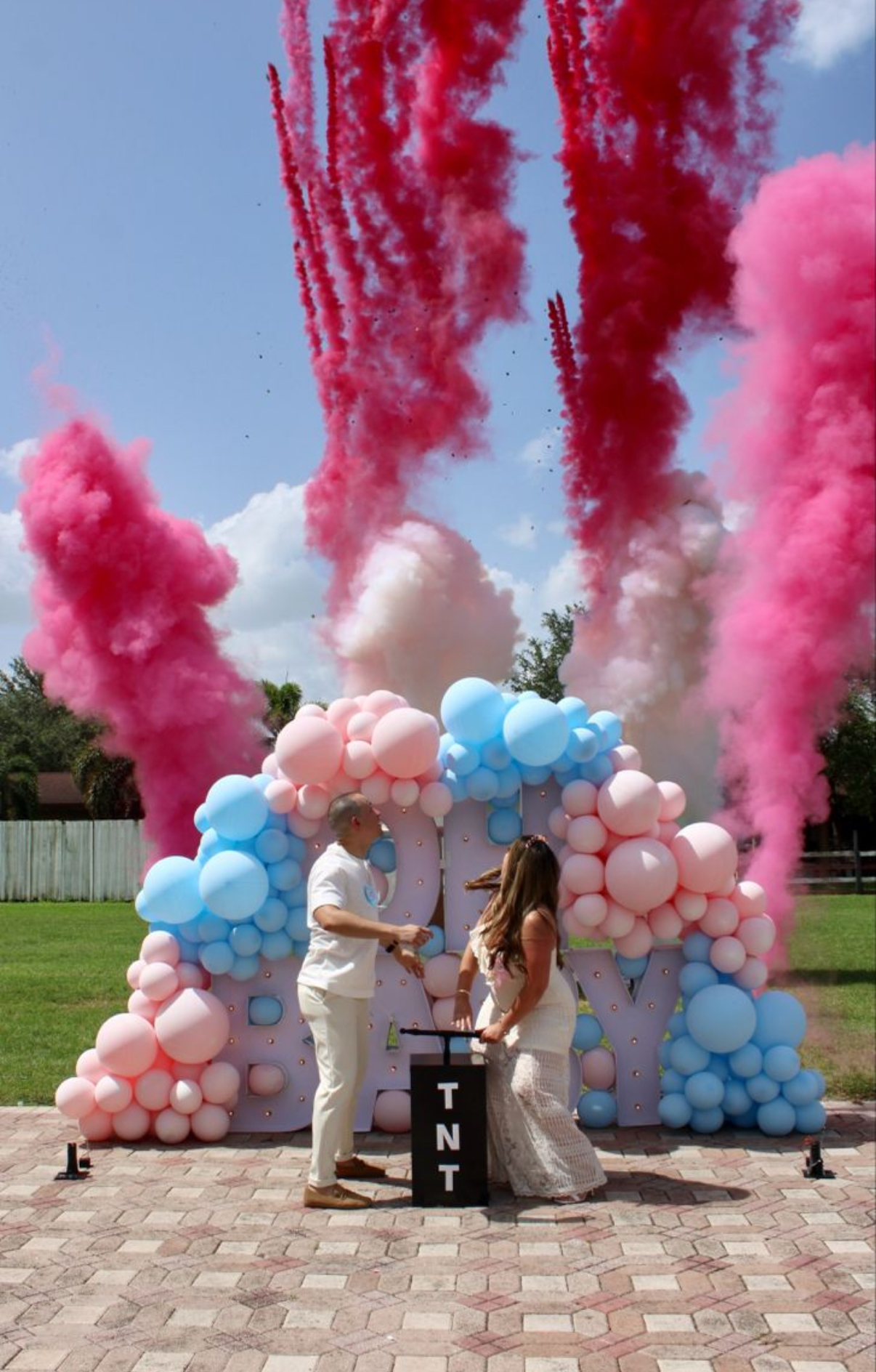 Oh Baby gender reveal balloon backdrop with pink and blue balloons and pink smoke cannons in Miami